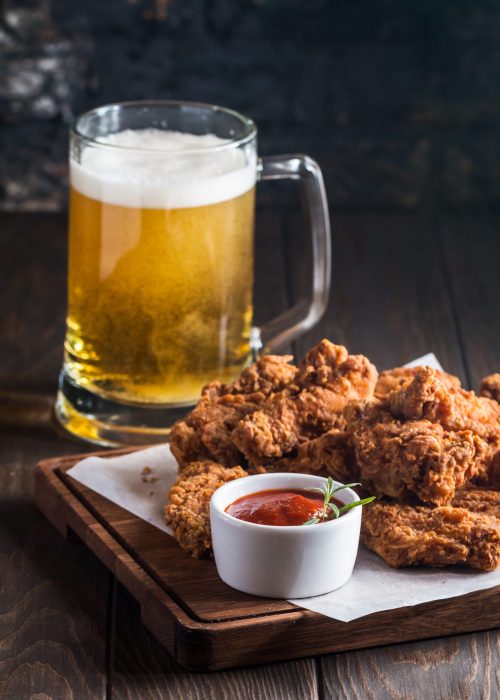 Buffalo style chicken wings served with cold beer on wooden background